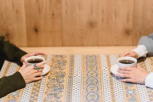 コーヒーカップを持った向かい合うふたり