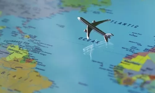 世界地図の上を飛ぶ飛行機