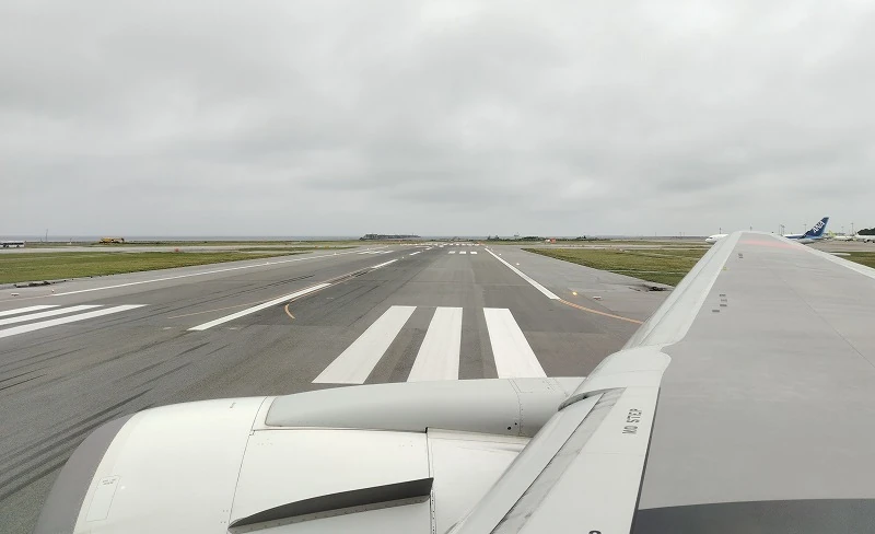 飛行機の羽の上の座席から見える空港の滑走路